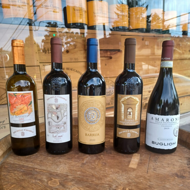 five bottles of wine on top of an empty wine barrel