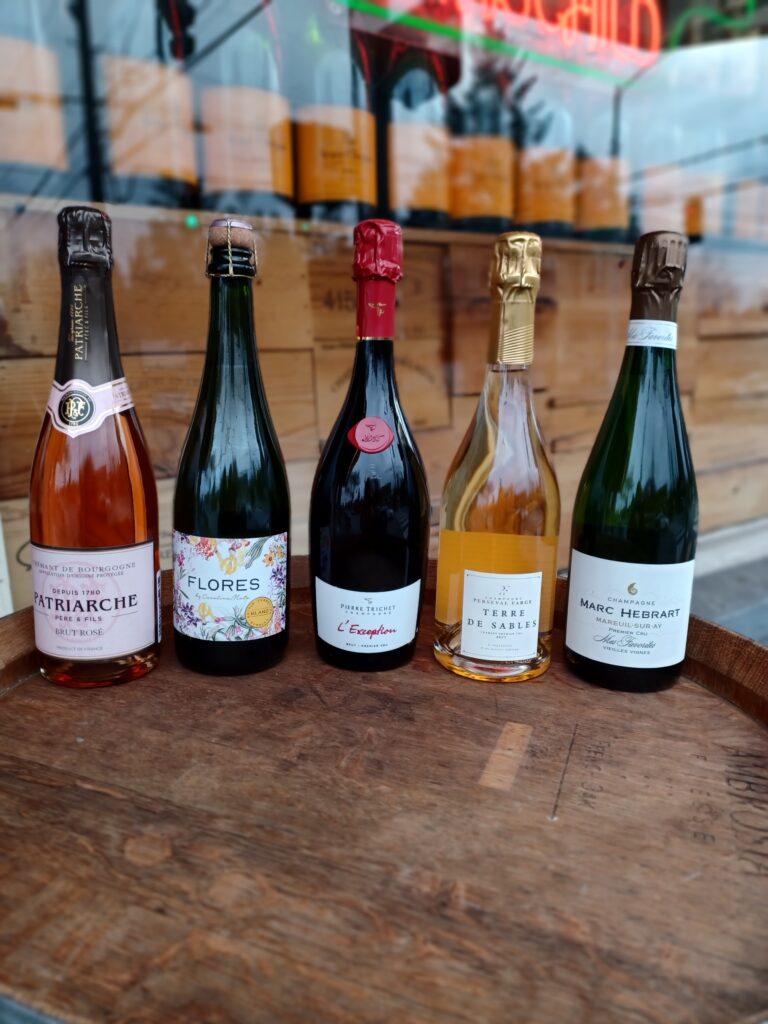 five wine bottles lined up on wine barrel