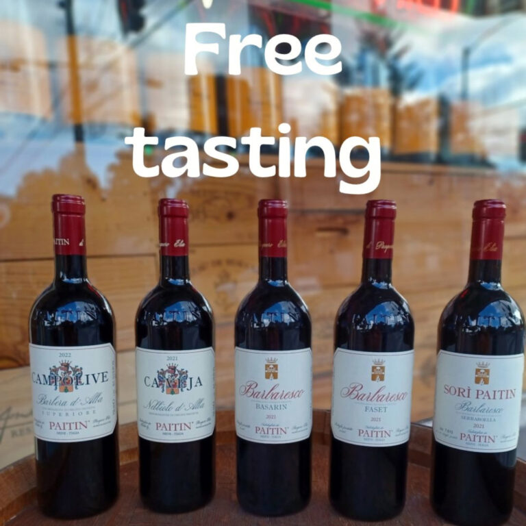 five bottles of wine sitting on top of a wine barrel